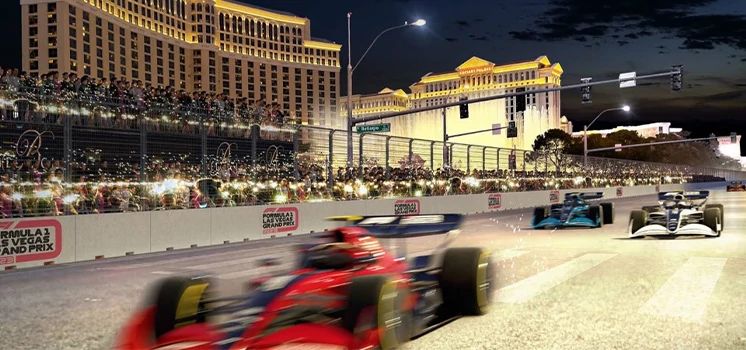 Formula 1 cars racing down the Las Vegas Strip at night, with bright casino lights in the background.
